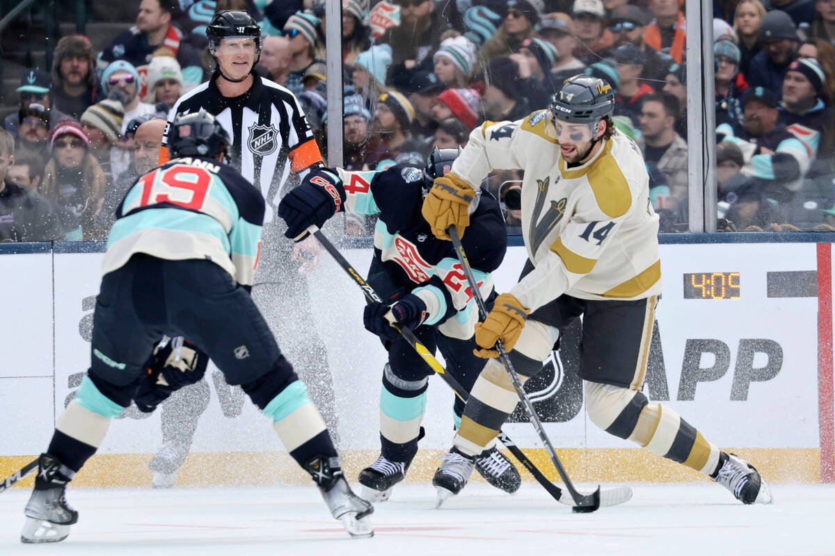 Vegas Golden Knights defenseman Nicolas Hague (14) passes the puck with Seattle Kraken defensem ...