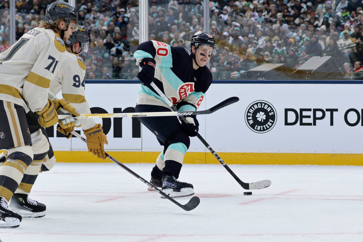 Seattle Kraken right wing Eeli Tolvanen (20) works to control the puck with Vegas Golden Knight ...