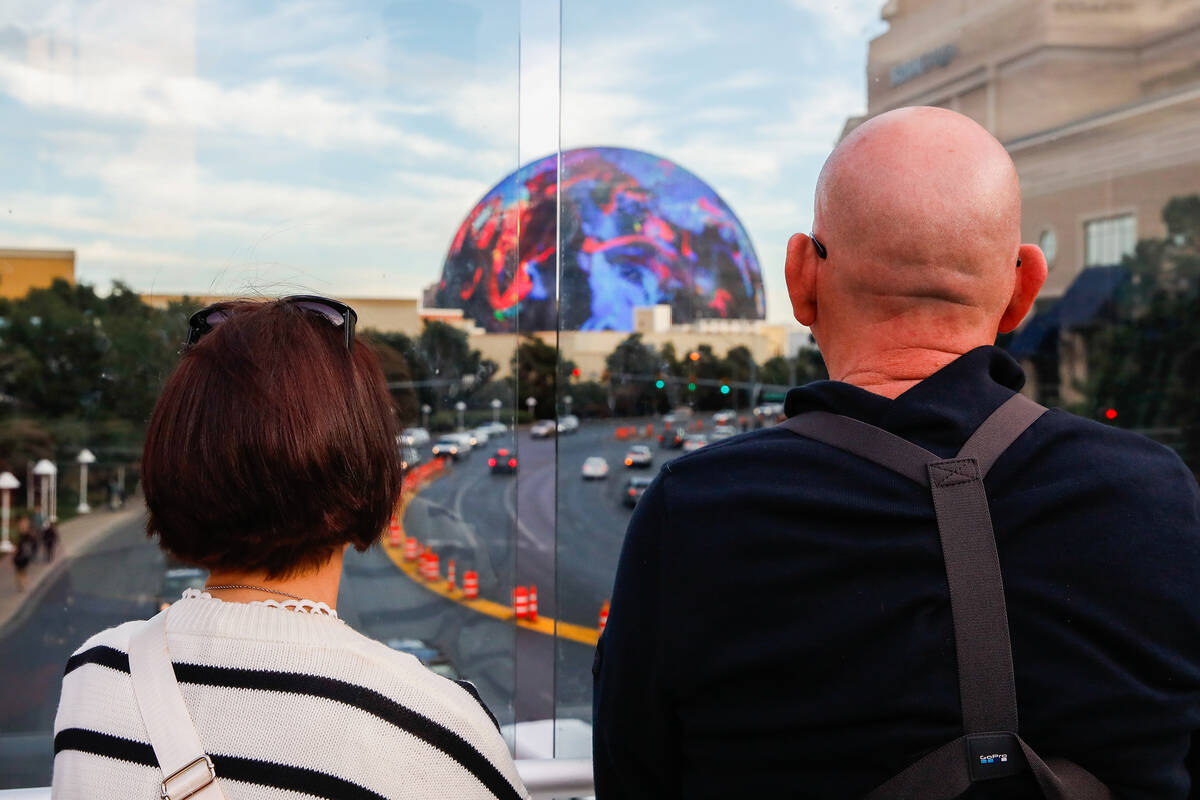 Tourists admire the sphere from a pedestrian bridge that crosses over Sands Avenue on Tuesday, ...