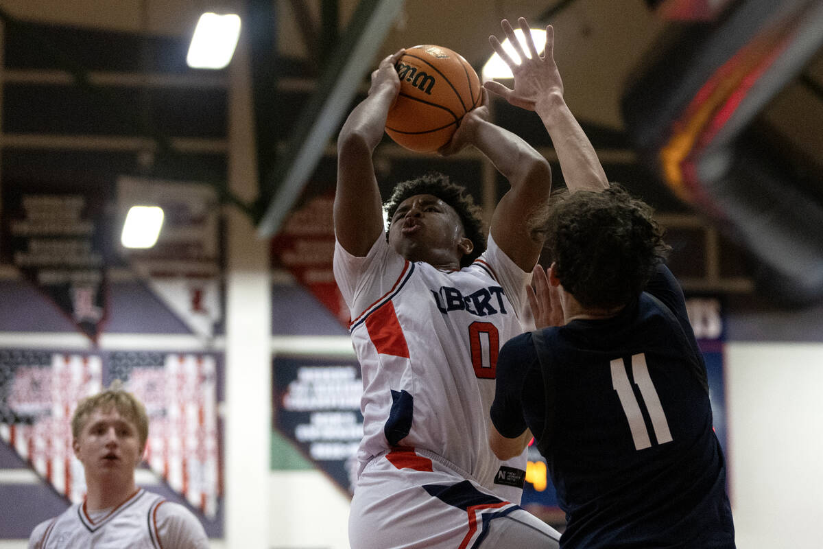 Liberty guard Tyus Thomas (0) shoots against Centennial guard Jaxon Price (11) during the secon ...