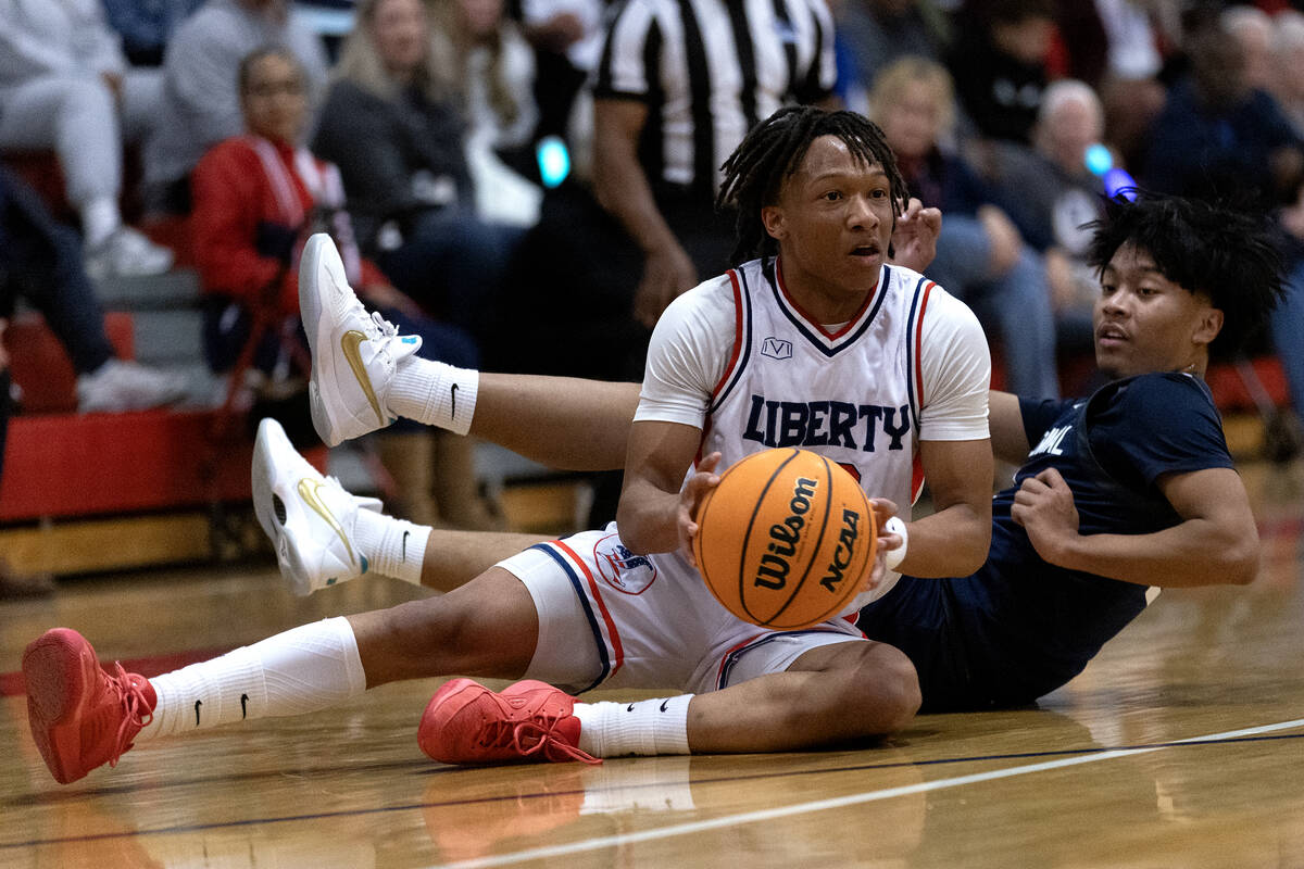 Liberty guard Jaden Riley (13) passes from the court after tangling with Centennial guard Aiden ...