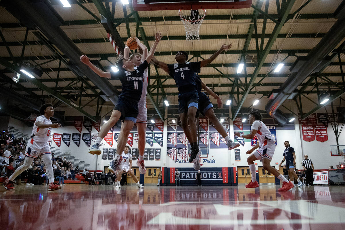 Liberty forward Tyler Bright (25) snags a rebound from Centennial guard Jaxon Price (11) and gu ...