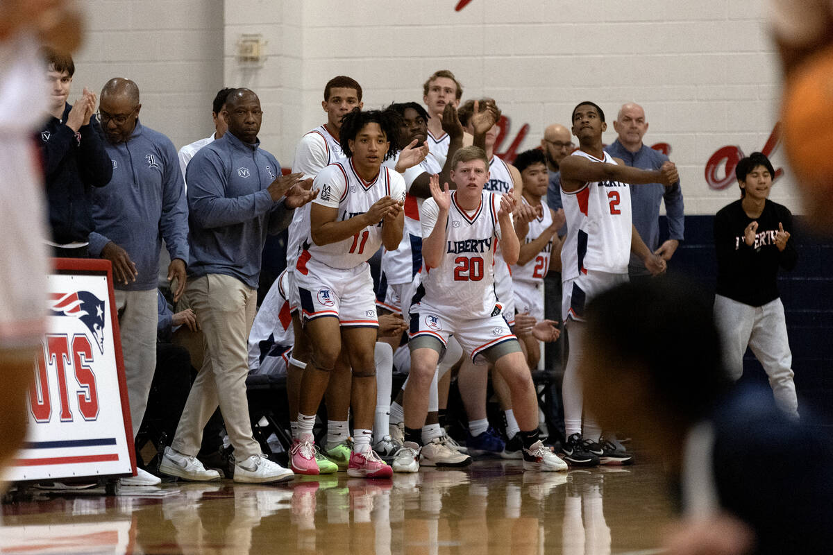 The Liberty bench cheers as Centennial is charged with a foul during the second half of a boys ...