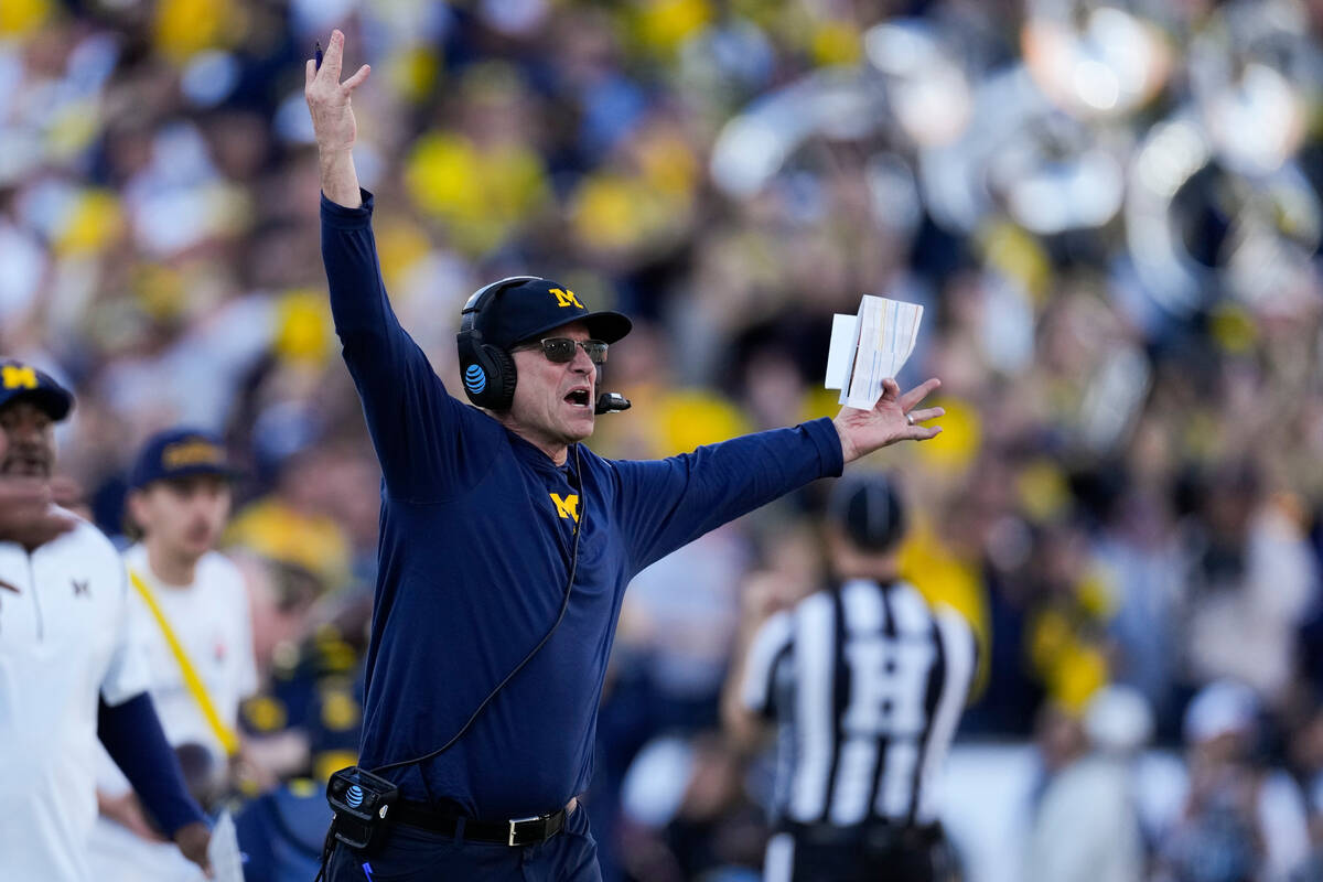 Michigan head coach Jim Harbaugh gestures from the sideline during the first half in the Rose B ...