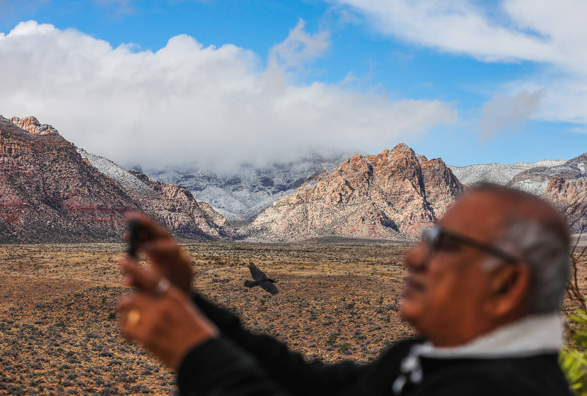 M.P. Das, visiting from India, takes a photo of Red Rock Canyon after a dusting of snow blanket ...