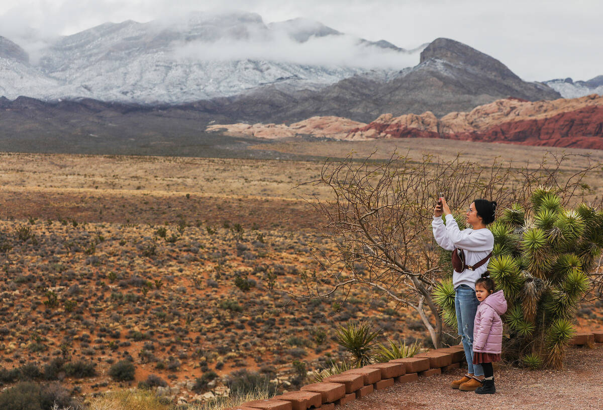 Visitors take pictures of Red Rock Canyon after a dusting of snow blankets the mountains on Wed ...