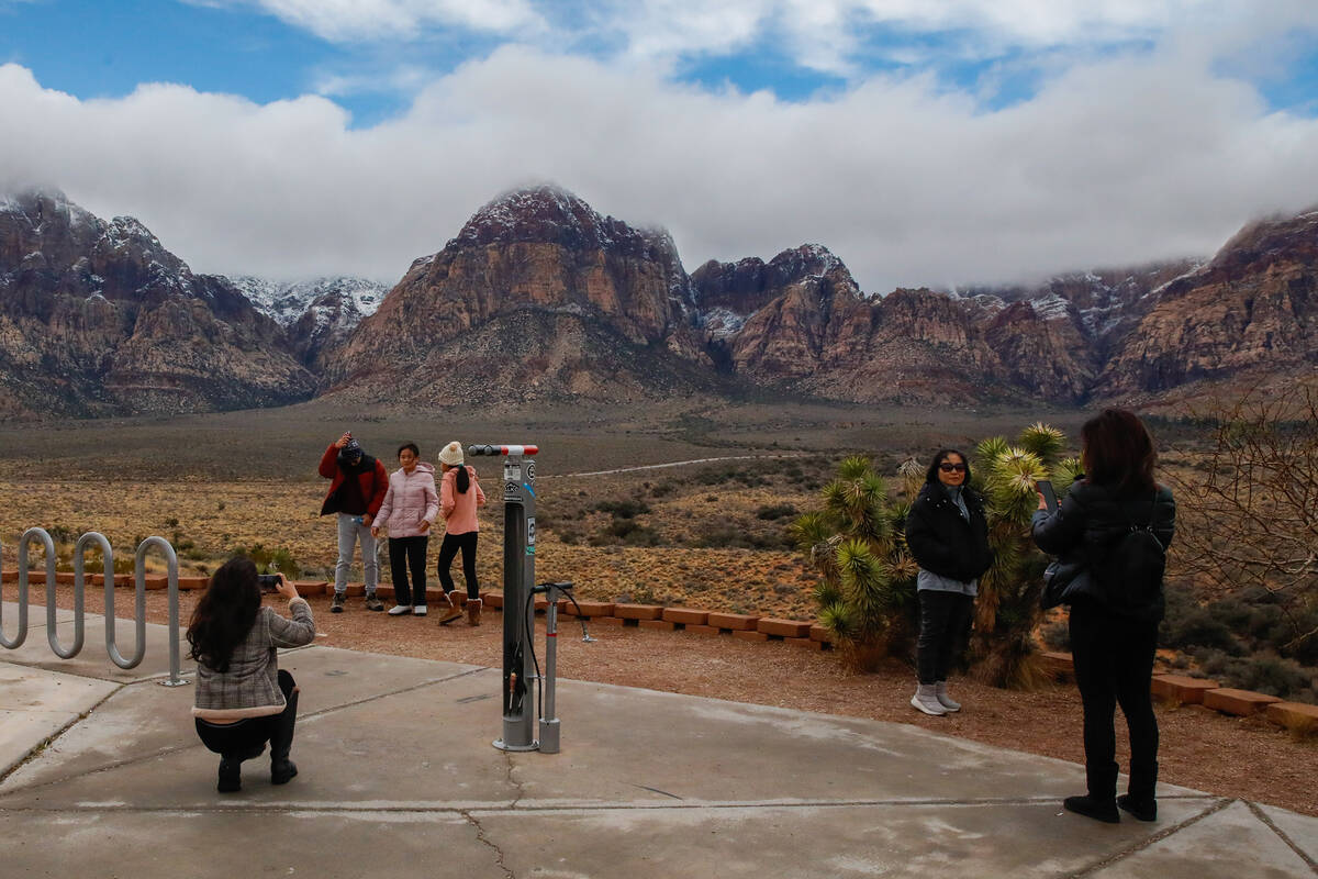 Visitors take pictures of Red Rock Canyon after a dusting of snow blankets the mountains on Wed ...