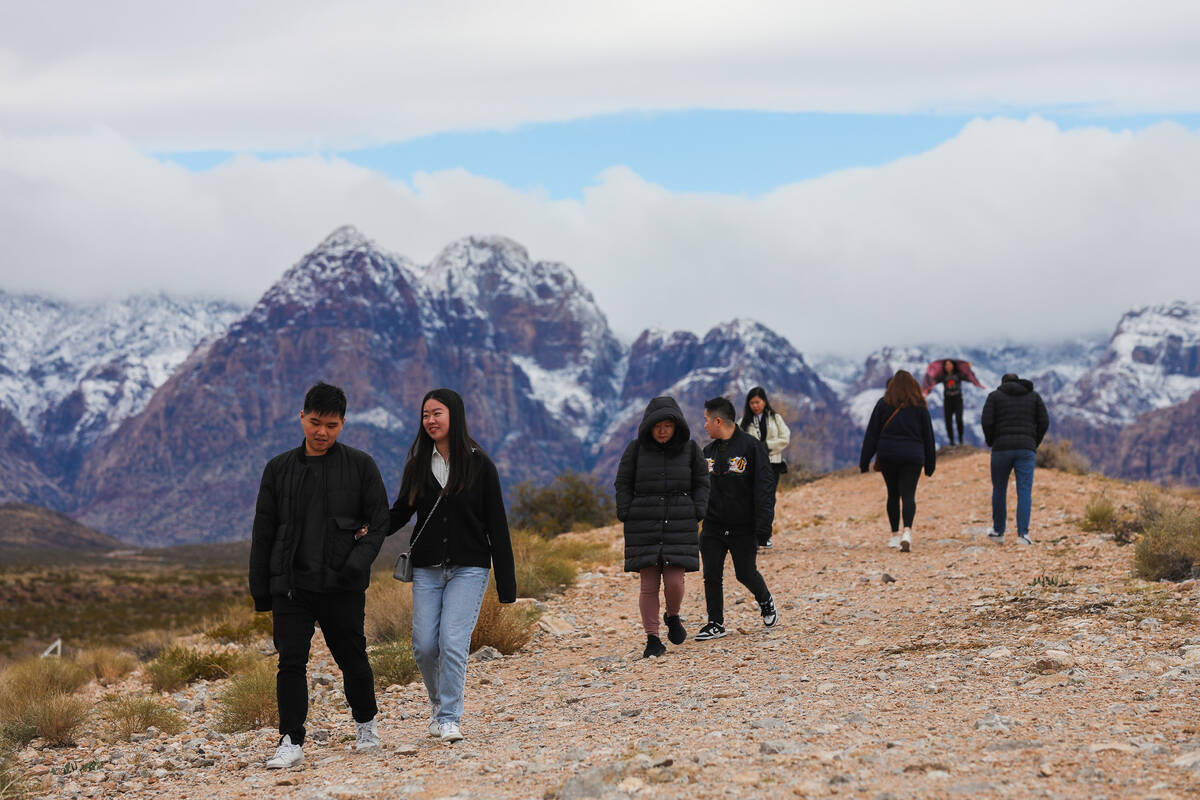 Visitors explore Red Rock Canyon after a dusting of snow blankets the mountains on Wednesday, J ...