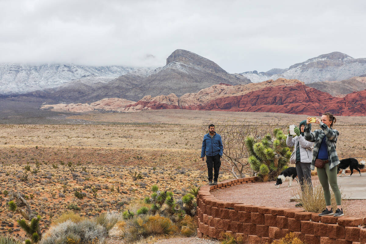 Visitors take pictures of Red Rock Canyon after a dusting of snow blankets the mountains on Wed ...