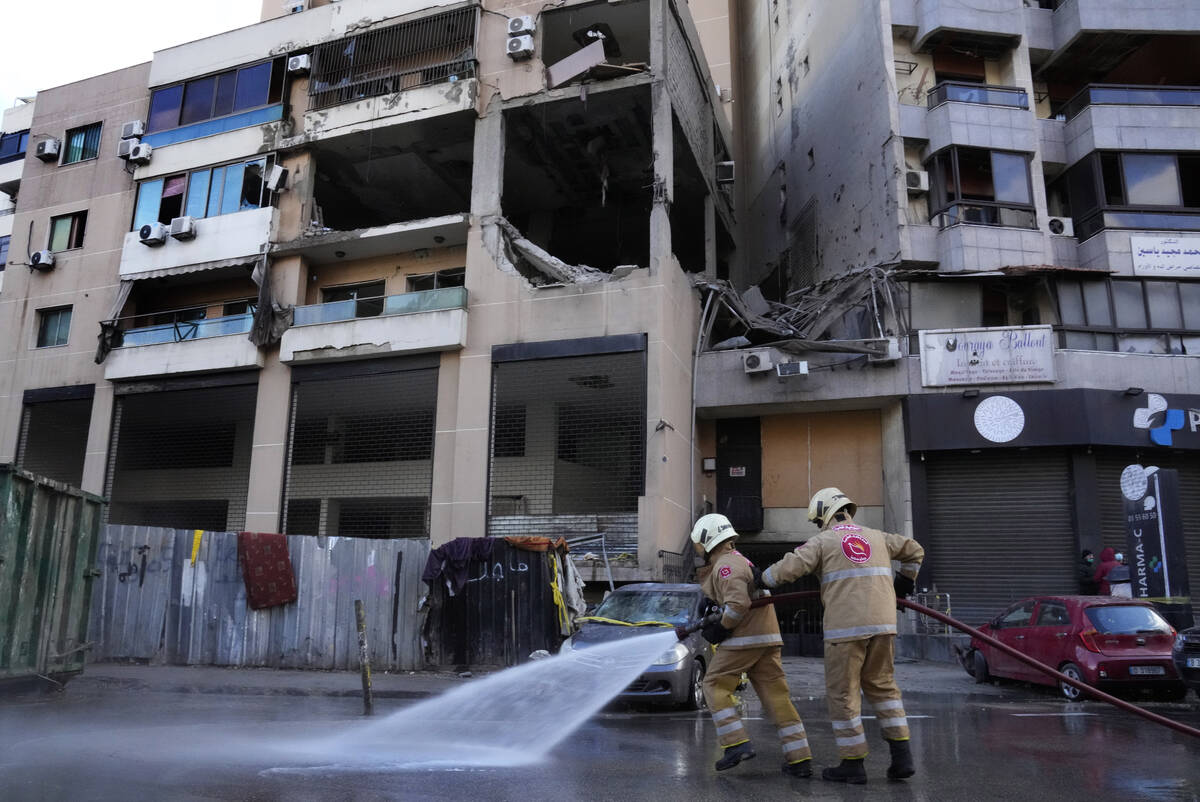 Civil defense workers clean the street in front of an apartment building where an apparent Isra ...