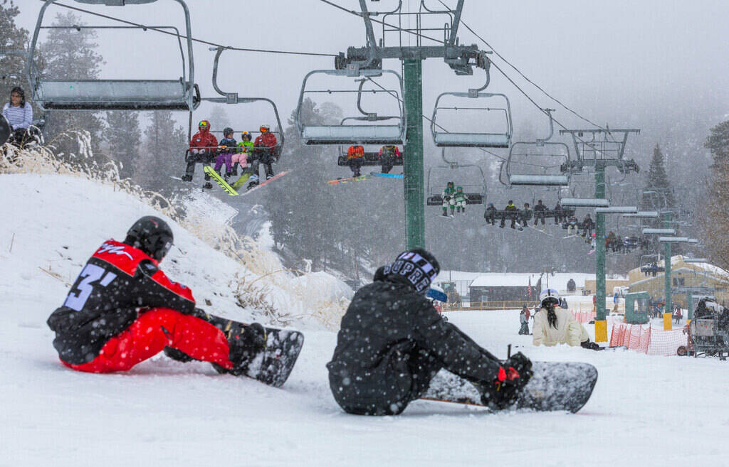 Skiers and snowboarders use the beginner lift and hill at the Lee Canyon Ski Resort as snow fal ...