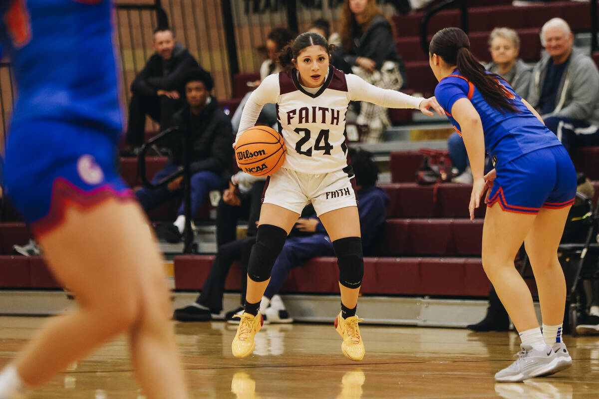 Faith Lutheran’s London Camacho (24) keeps the ball in her hand as she looks to pass it ...
