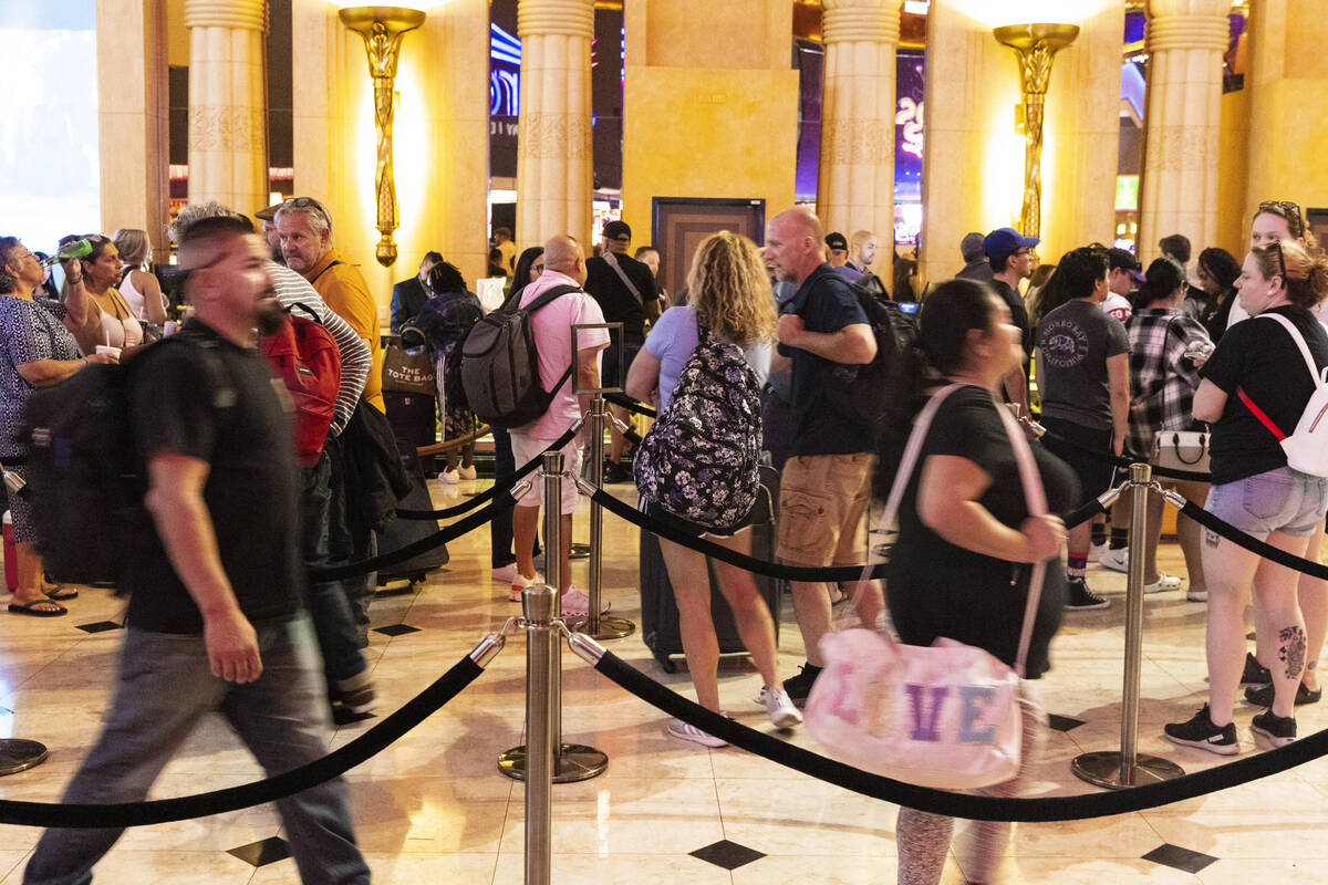 Hotel guests wait in line as they check in at Luxor hotel-casino, on Thursday, Sept. 14, 2023, ...