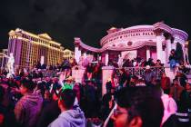 Crowds of people line the Strip in front of Caesars Palace for New Year celebrations on Sunday, ...