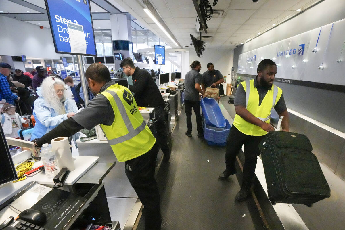File - Agents check-in passengers and their baggage at George Bush Intercontinental Airport on ...
