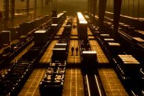 Workers walk among shipping containers at a BNSF intermodal terminal, Wednesday, Jan. 3, 2024, ...
