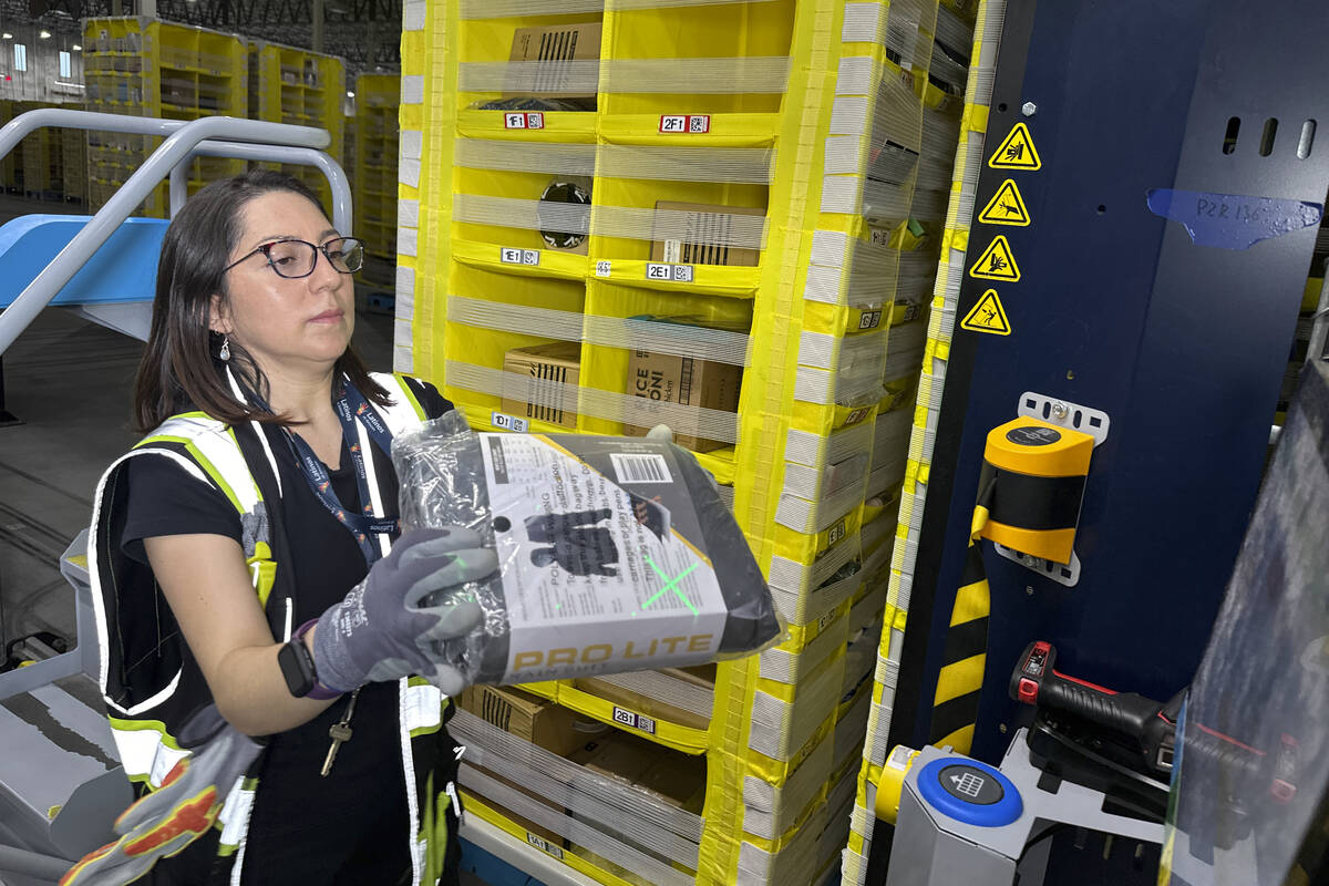A worker moves a package at an Amazon same-day delivery shipping center in Woodland Park, New J ...