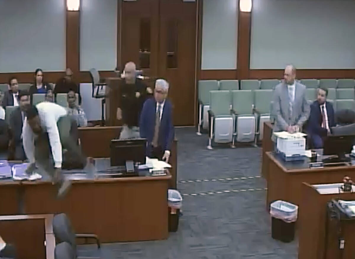 This is a video screen shot of defendant Deobra Redden leaping a table to attack Judge Mary Kay ...