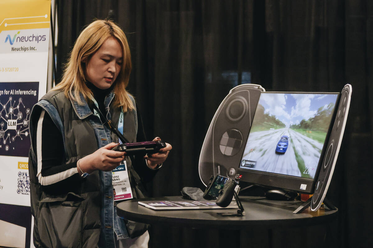 An CES attendee tries a “cloud gaming controller” by Serafim during CES Unveiled ...