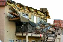 Debris is scattered about the upstairs landing and below from an apartment building roof collap ...