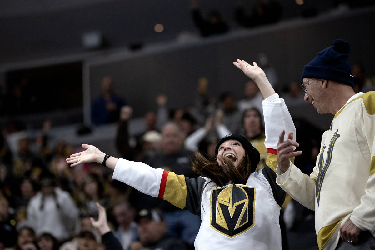A Golden Knights fan cheers for her team during the third period of an NHL hockey game against ...