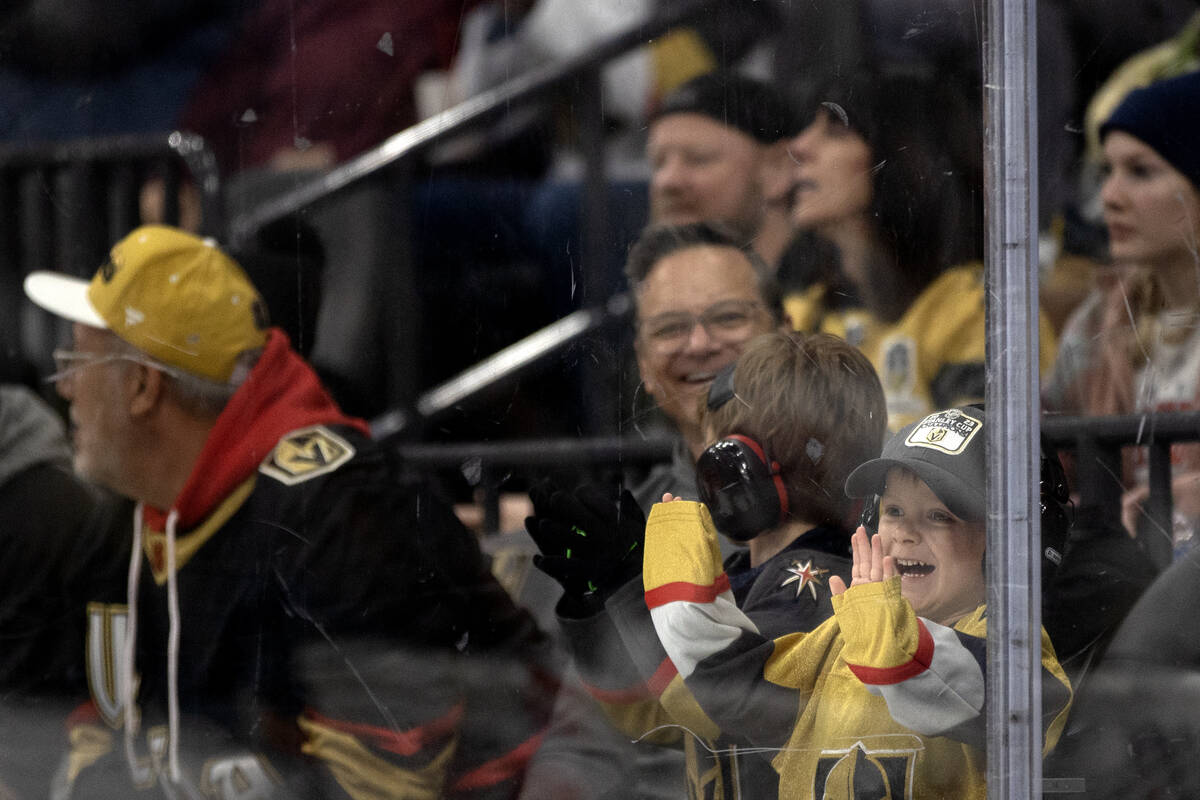A young Golden Knights fan smacks the boards during the third period of an NHL hockey game agai ...