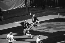Los Angeles Raiders Jack Squirek (58) holds the ball aloft in the end zone after intercepting a ...