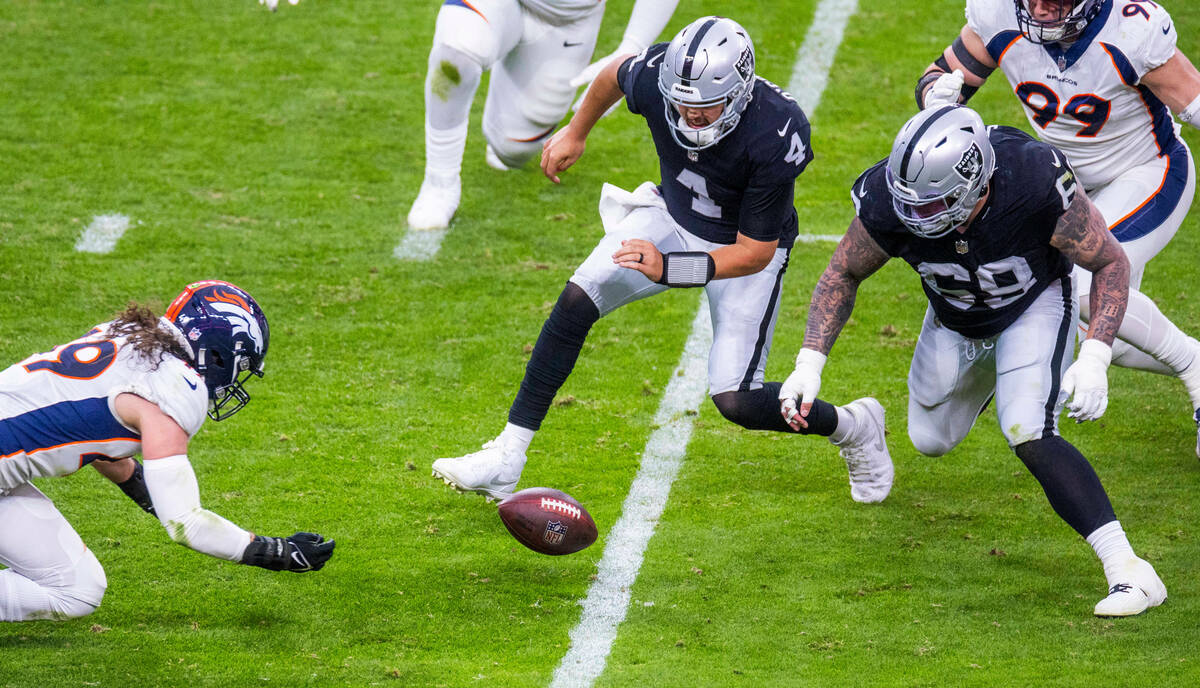 Raiders quarterback Aidan O'Connell (4) looks to a loose ball as Denver Broncos linebacker Alex ...