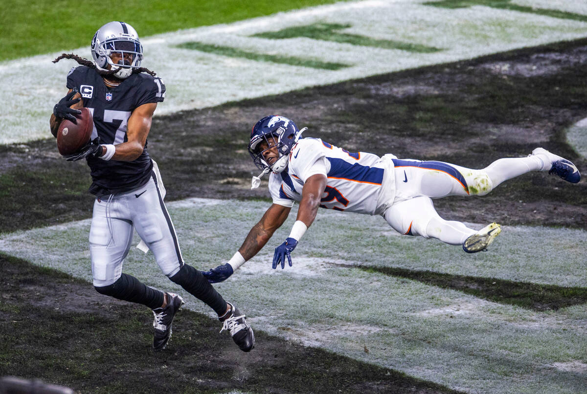Raiders wide receiver Davante Adams (17) secures a touchdown pass as Denver Broncos cornerback ...