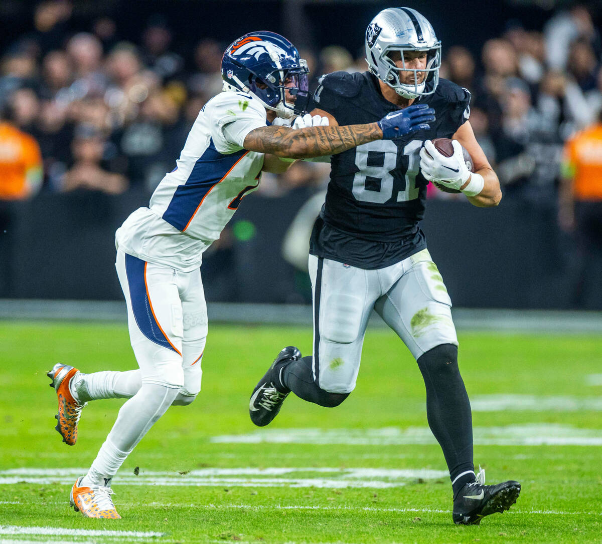 Raiders tight end Austin Hooper (81) fights for more yards against Denver Broncos cornerback Pa ...
