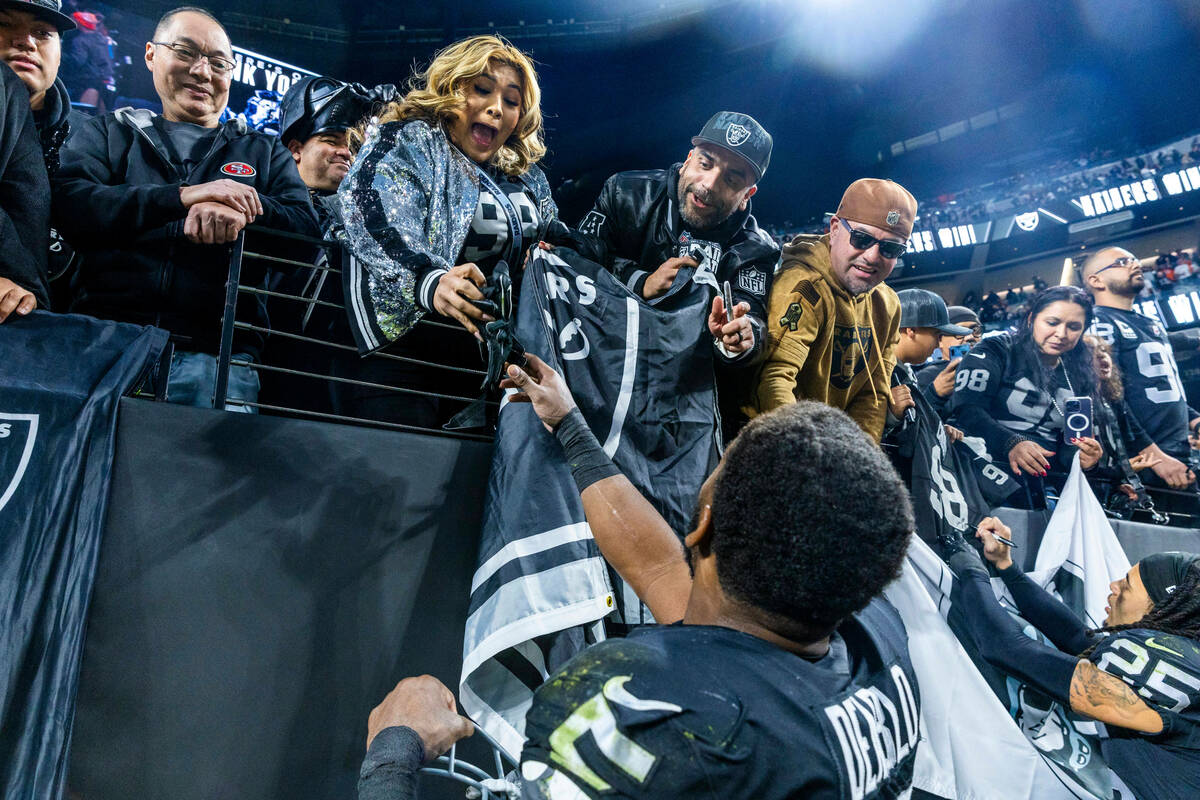 Raiders linebacker Divine Deablo (5) excites a fan with a glove after defeating the Denver Bron ...