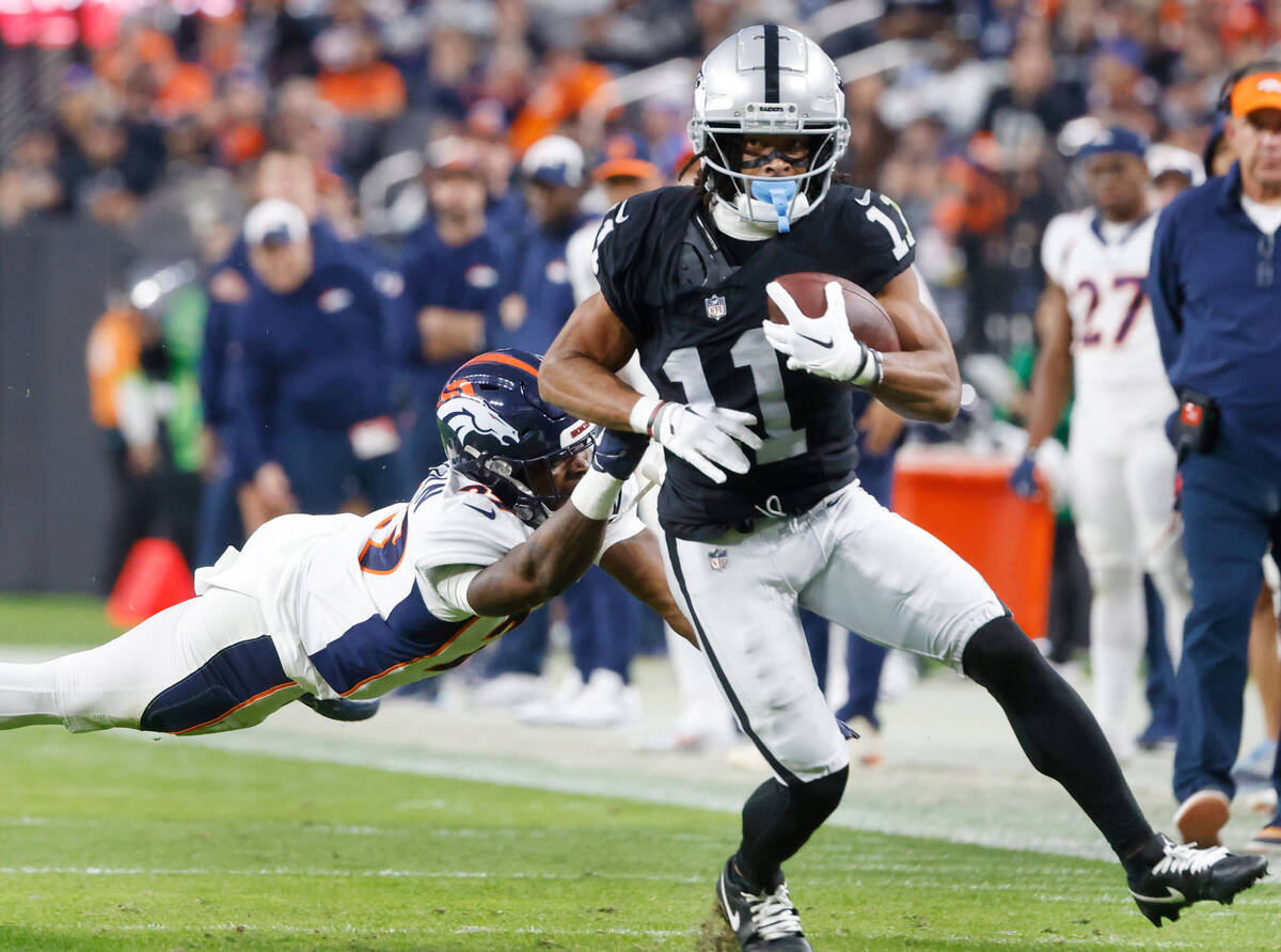 Raiders wide receiver Tre Tucker (11) avoids a tackle from Denver Broncos cornerback Ja'Quan Mc ...