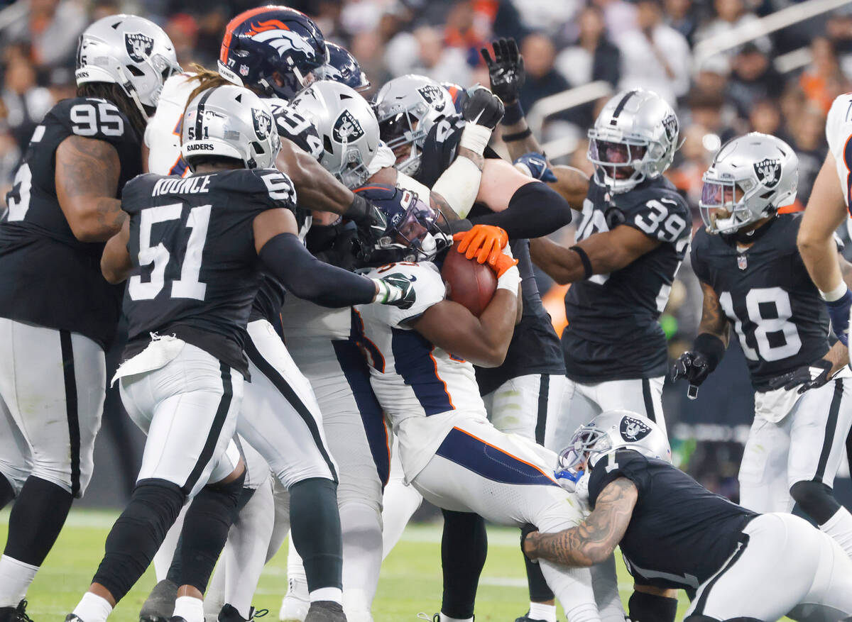 Denver Broncos running back Javonte Williams (33) is tackled by Raiders defense during the seco ...