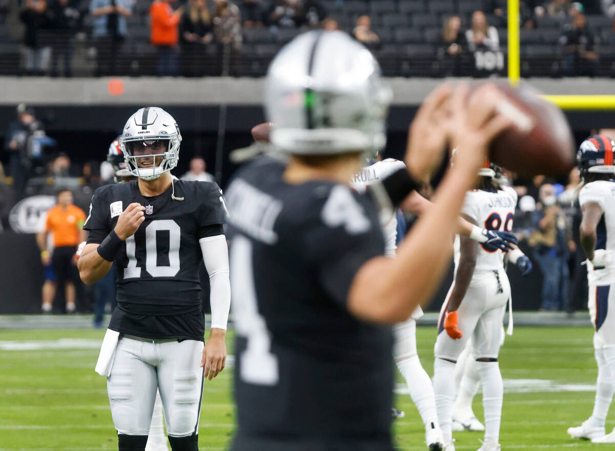 Raiders quarterback Jimmy Garoppolo (10) watches as quarterback Aidan O'Connell (4) warms up pr ...