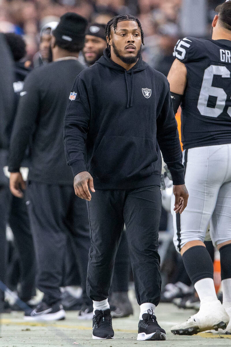 Raiders running back Josh Jacobs walks the sideline during the first half of an NFL game agains ...