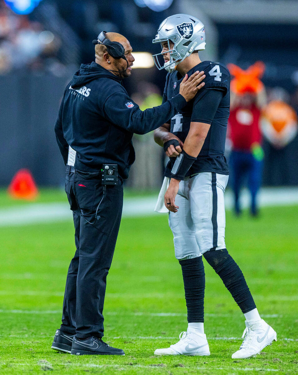 Raiders interim head coach Antonio Pierce chats with quarterback Aidan O'Connell (4) on a timeo ...