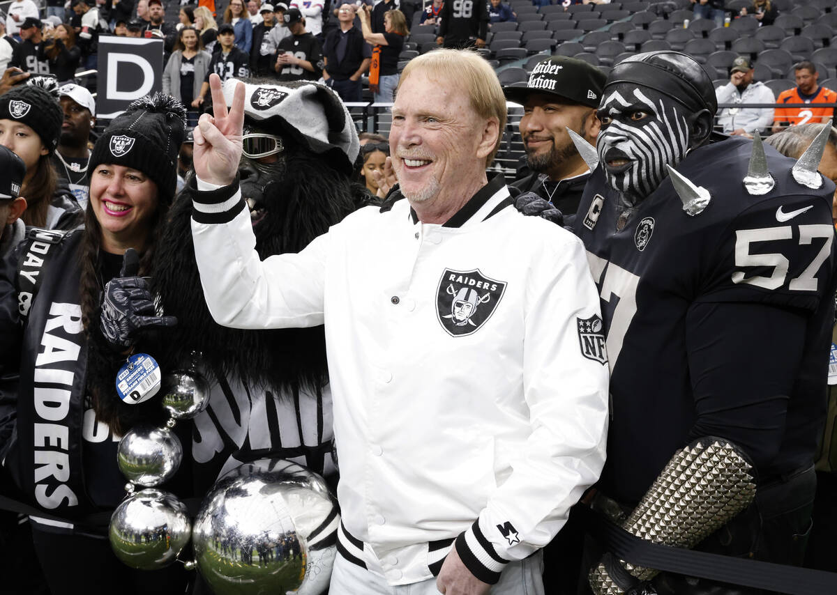 Raiders owner Mark Davis flashes a victory sign as he poses for a photo with fans prior to the ...