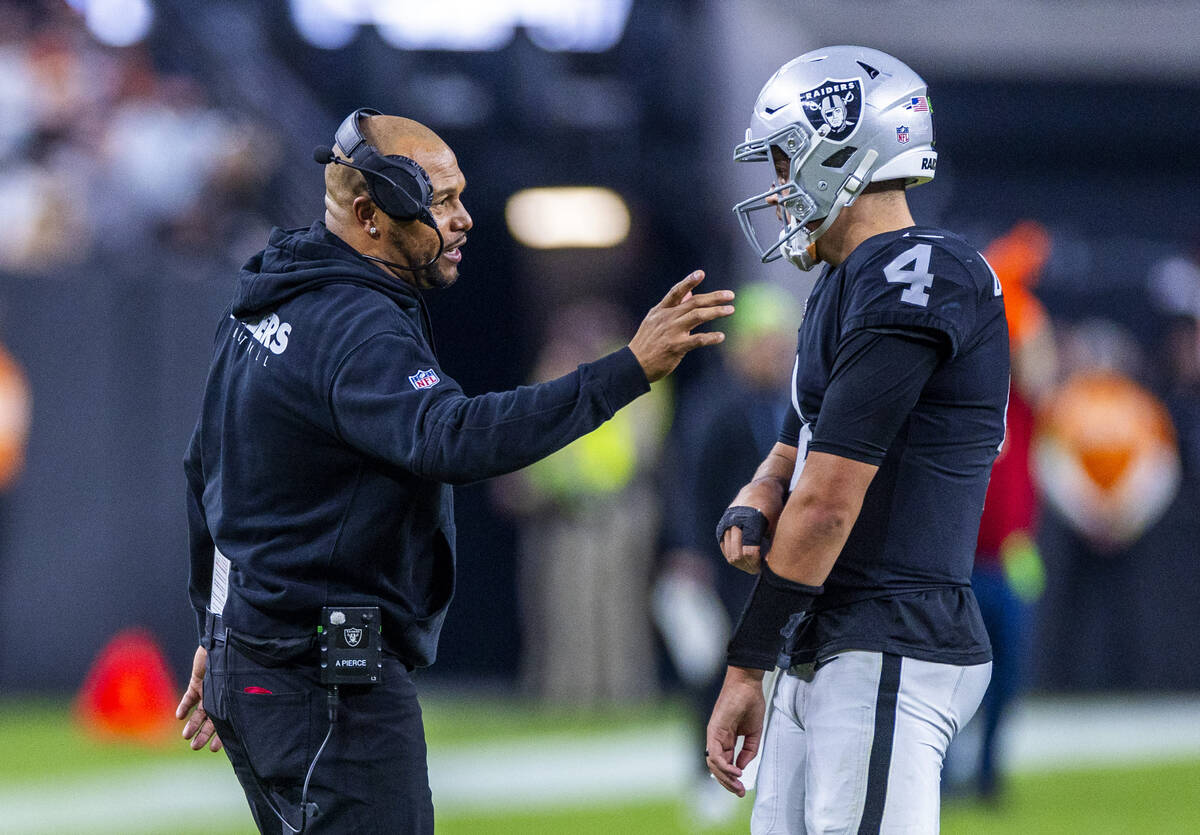 Raiders interim head coach Antonio Pierce chats with quarterback Aidan O'Connell (4) on a timeo ...