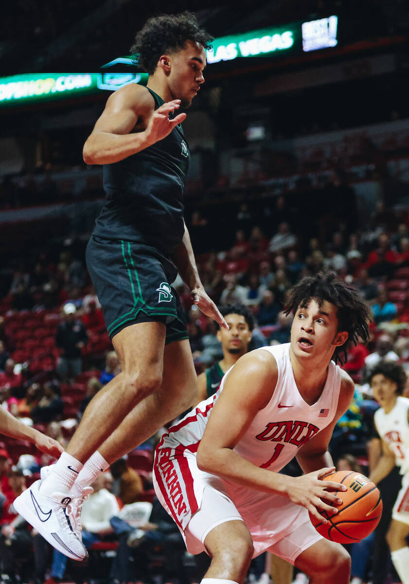 UNLV forward Jalen Hill (1) looks to pass the ball to a teammate as Stetson guard Alec Oglesby ...