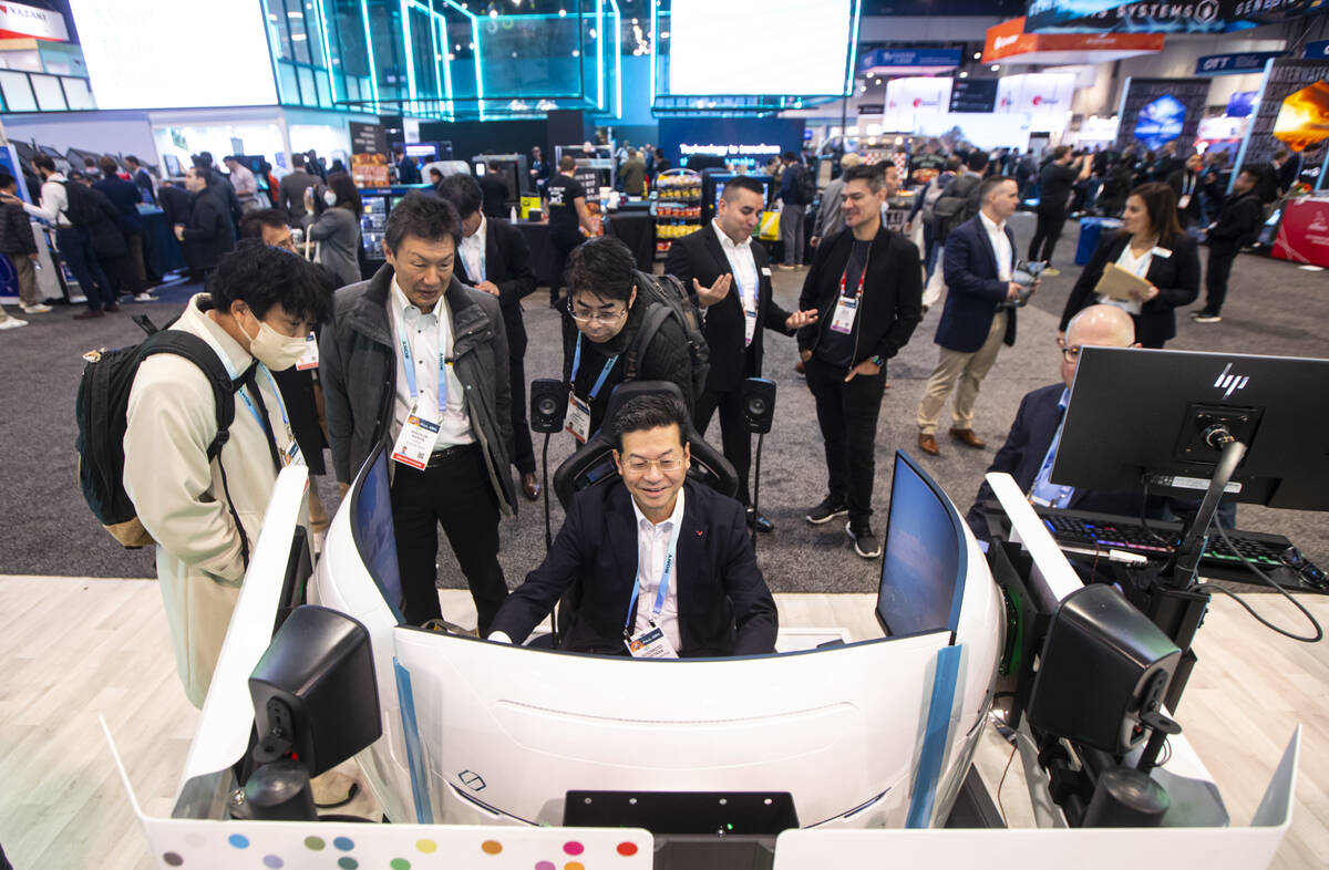 Sugimoto Hidetaka tries out a flight simulator at the Sensata Technologies booth during the fir ...