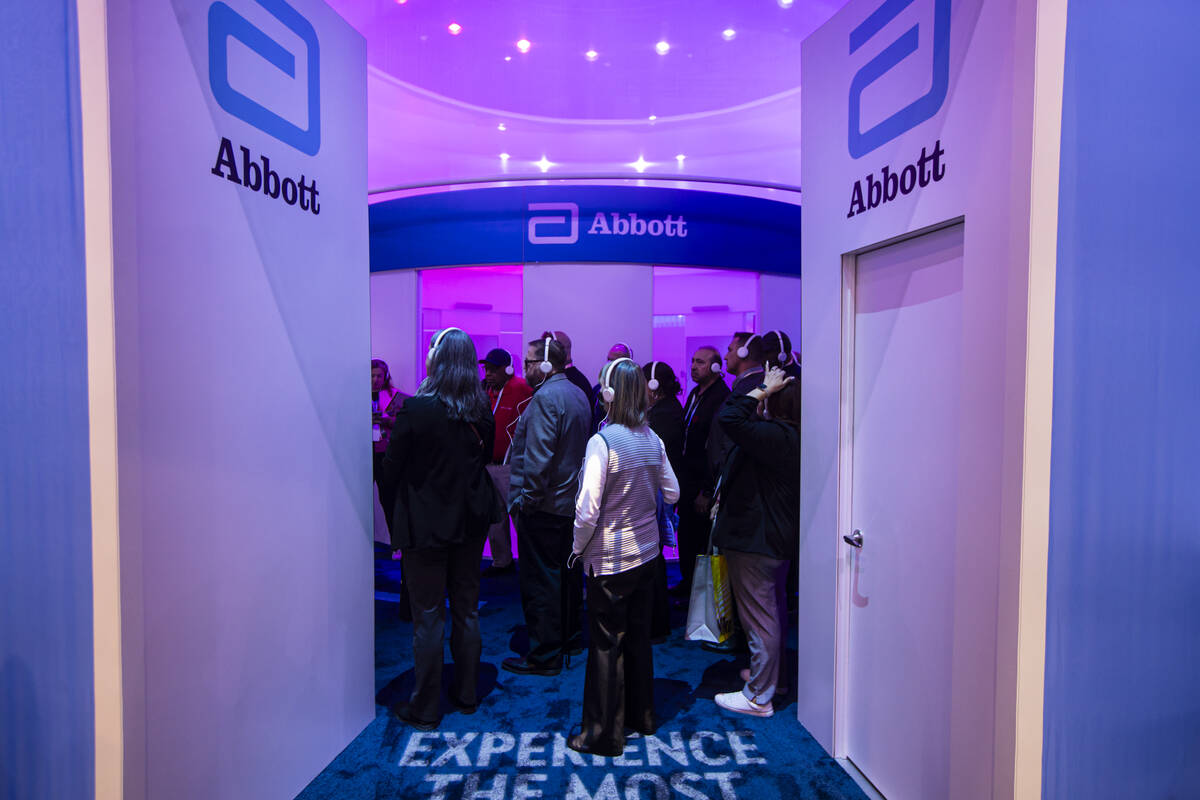 Attendees take a tour of the Abbott booth during the first day of CES at the Las Vegas Conventi ...