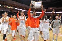 Bishop Gorman's Rashad Muhammad, holding trophy, is flanked by his teammates as they celebrate ...