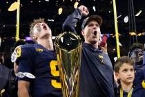 Michigan head coach Jim Harbaugh and quarterback J.J. McCarthy celebrate with the trophy after ...