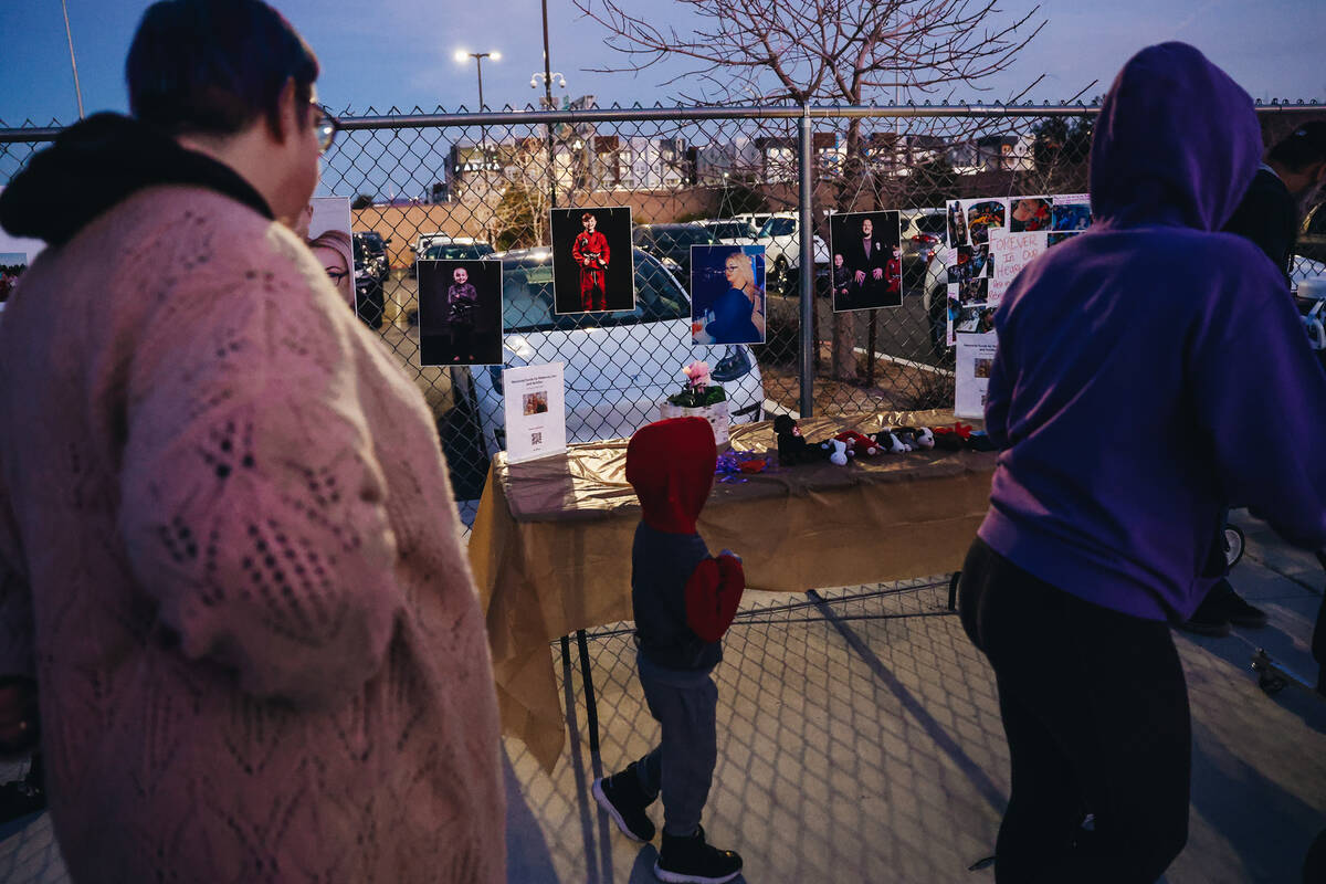 Mourners walk by photographs and posters during a vigil for Rebecca Post, Achilles Quintanilla ...