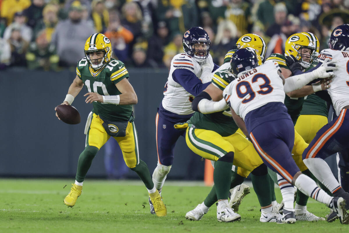 Green Bay Packers quarterback Jordan Love (10) scrambles out of the pocket during an NFL footba ...