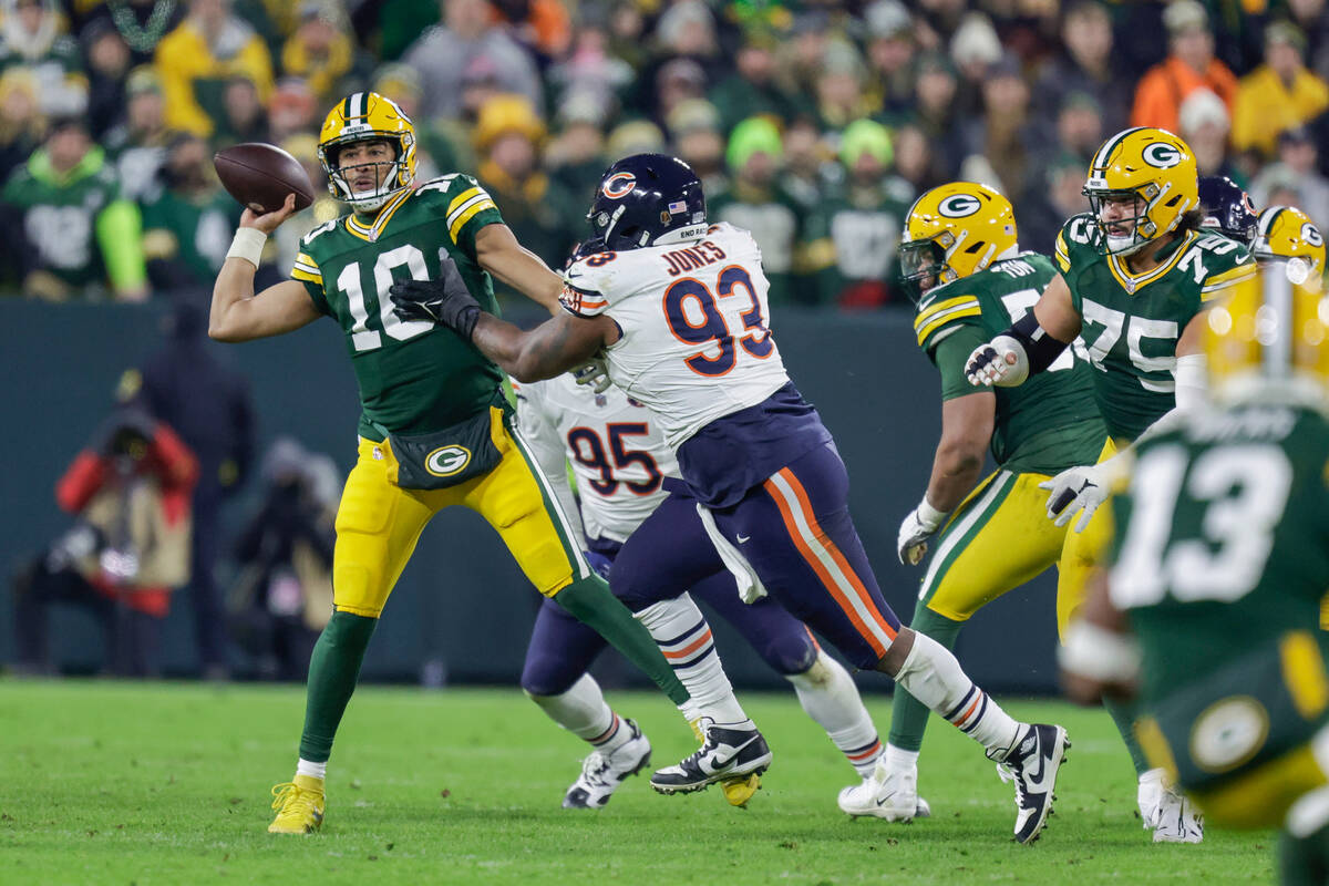 Green Bay Packers quarterback Jordan Love (10) is hit by Chicago Bears defensive tackle Justin ...