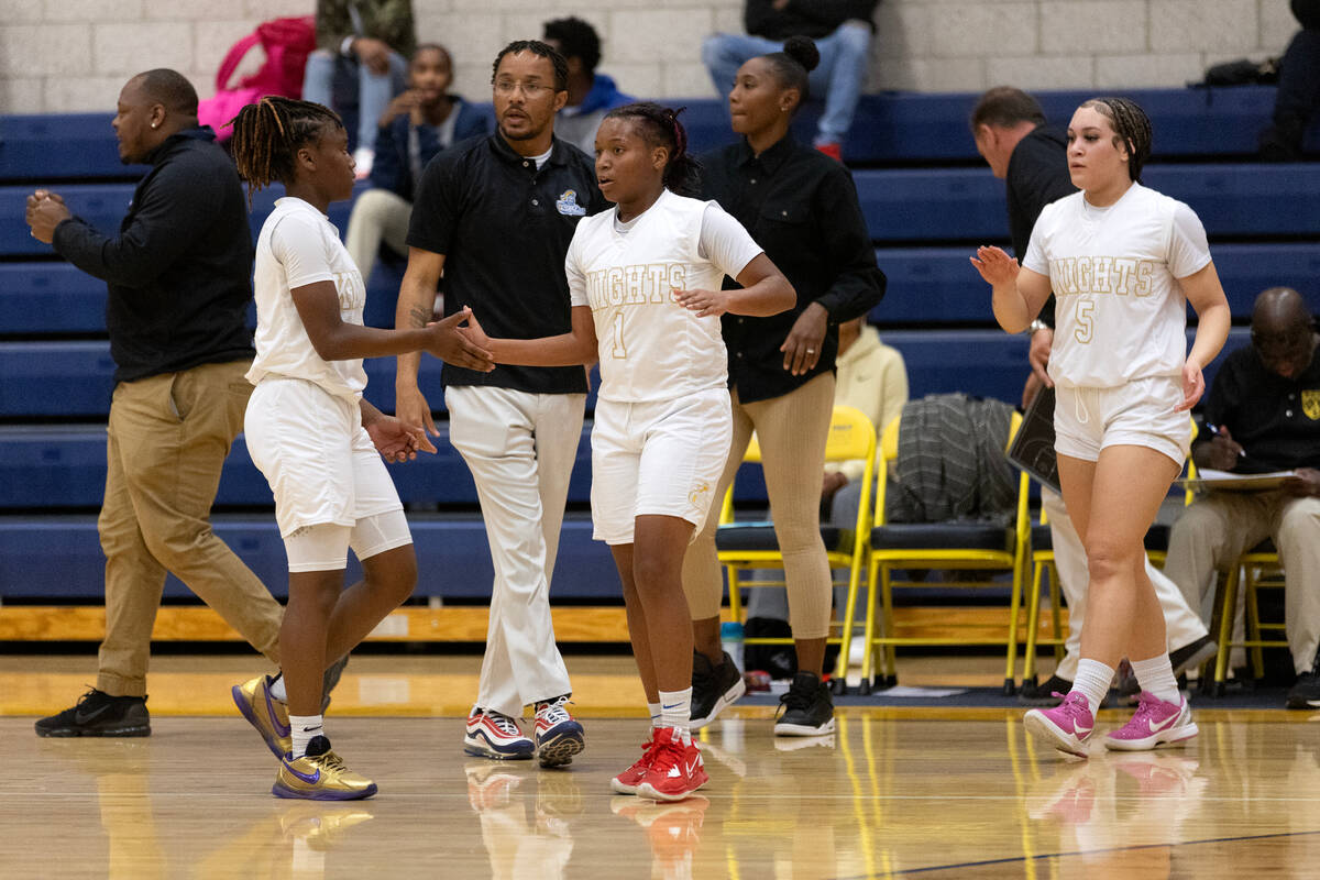 Democracy Prep’s Mikiah Verdum (1) and Bray’ana Miles (3) slap hands, with coach ...