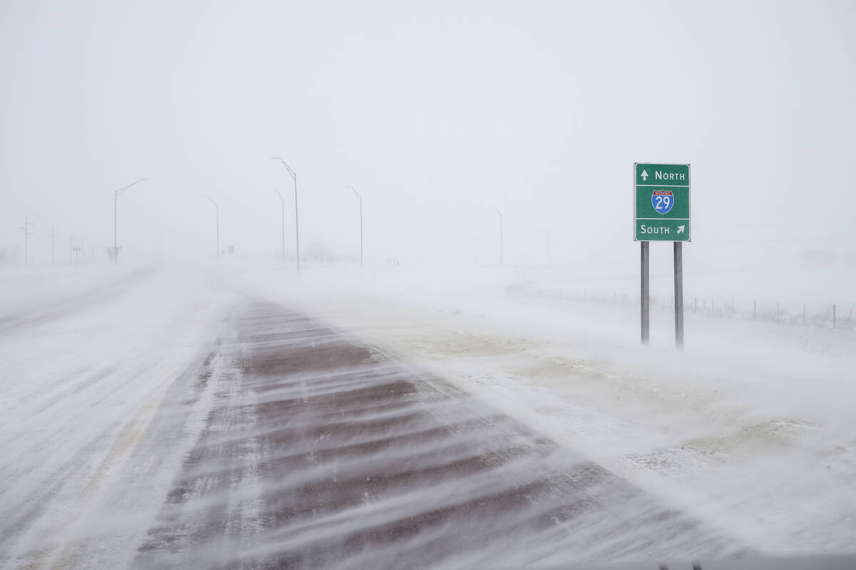 Snow blows across 260th street at the Interstate 29 overpass in Salix, Iowa, during a winter st ...