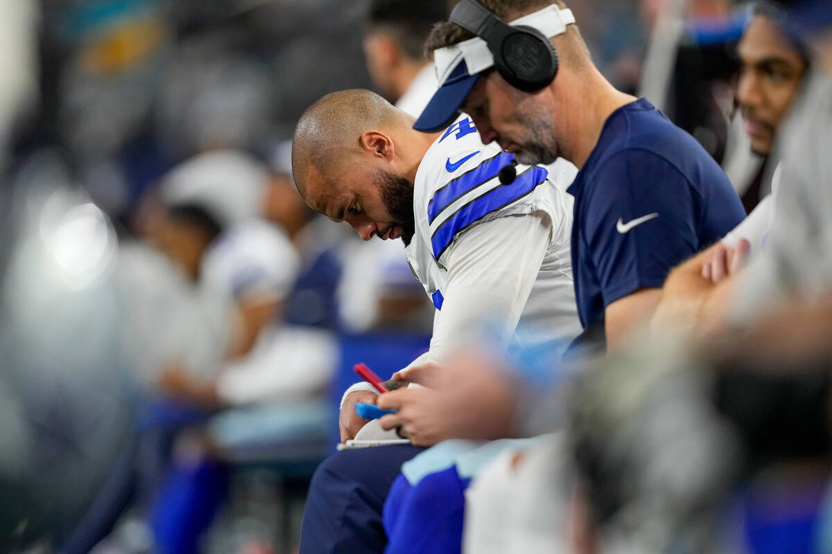 Dallas Cowboys quarterback Dak Prescott hangs his head while sitting on the bench during the se ...
