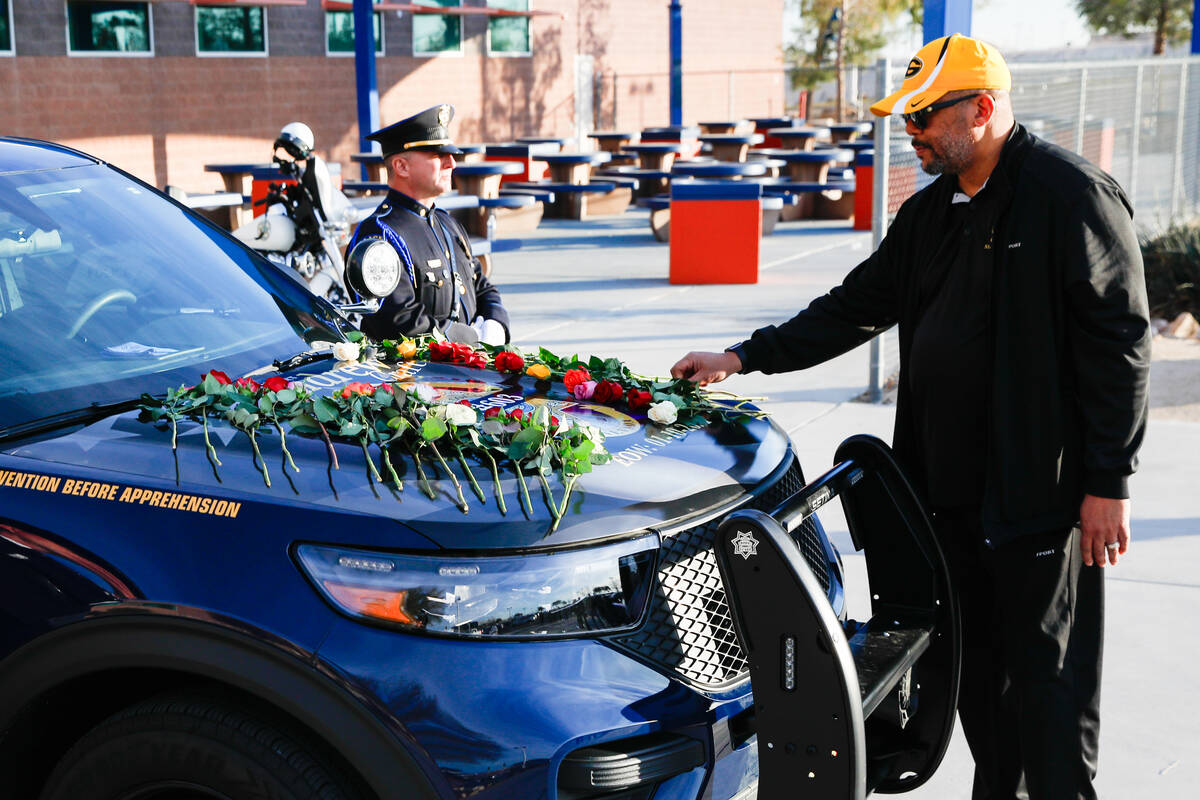 Retired CCSD Police Officer Phillip Garrett places a flower on the patrol vehicle of CCSD Polic ...